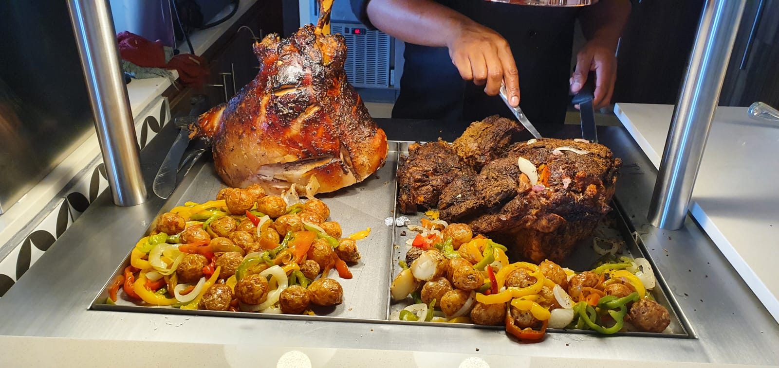 Chef carving roast pork and beef at the carvery