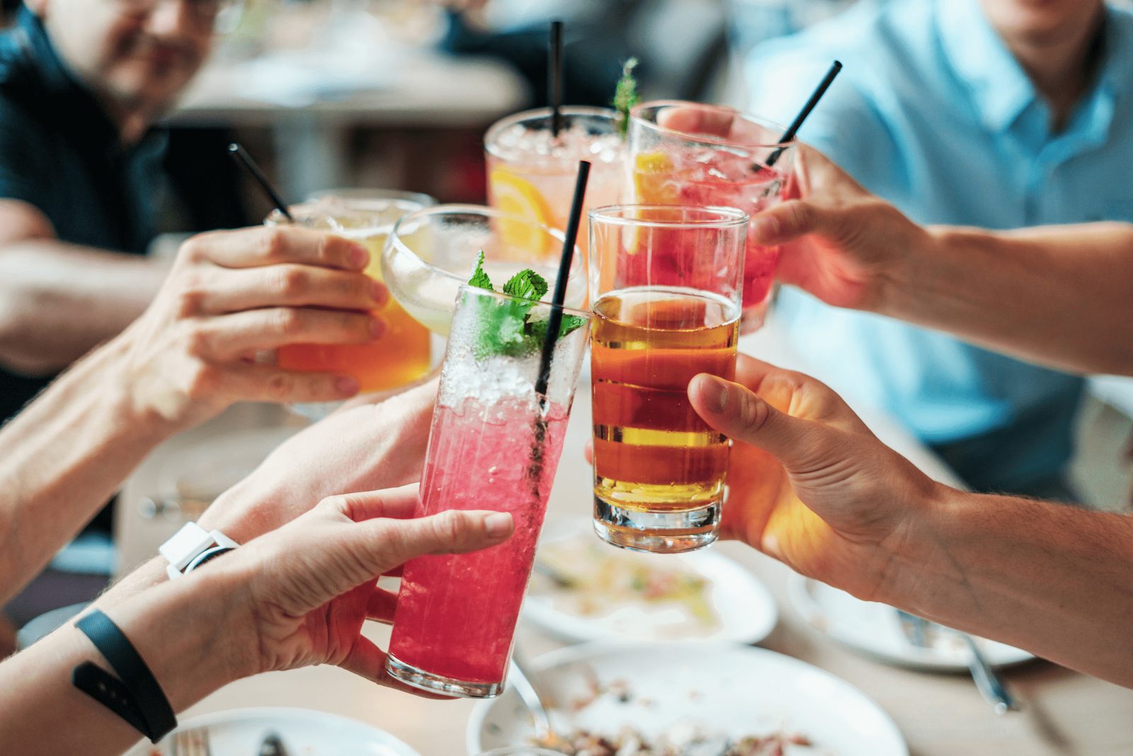 Friends raising cocktails together at the table
