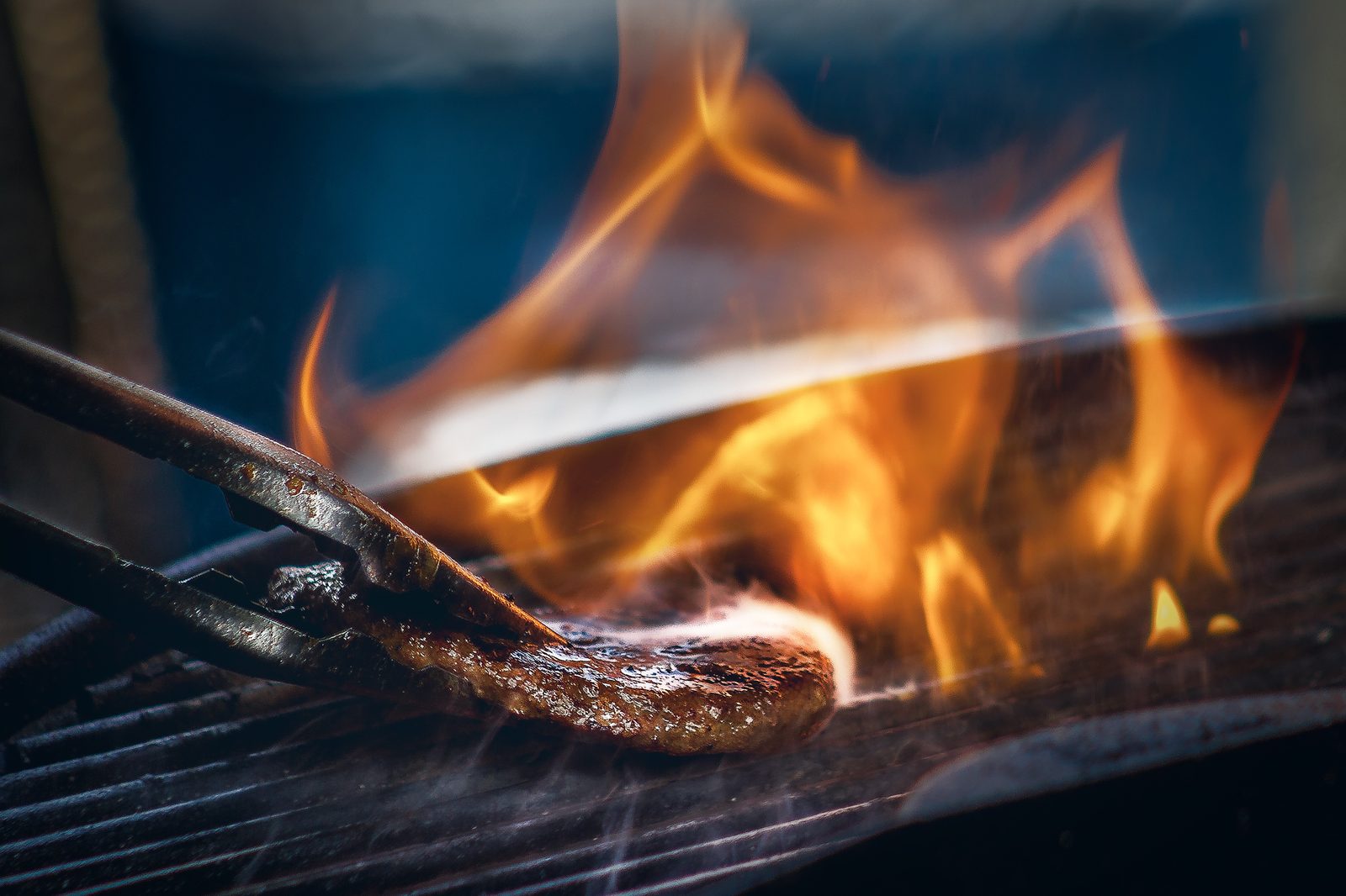 Steak searing over open flames on the grill